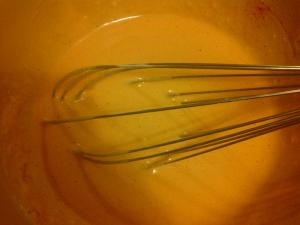 Whisking batter to ensure there are no lumps.
