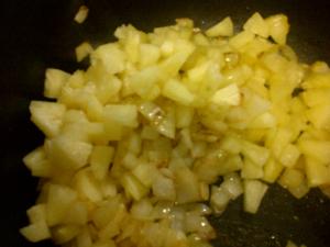 Frying the pineapple, garlic and onions.