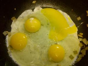 Crack eggs in wok and stir frequently.